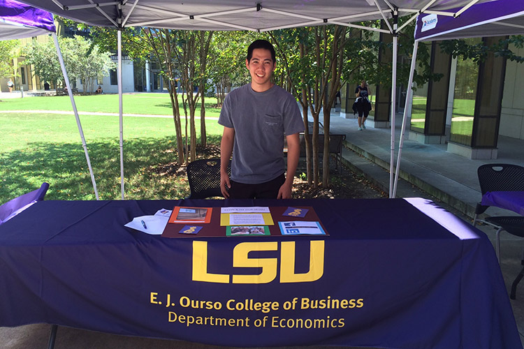 Student at economics table during organization fair.