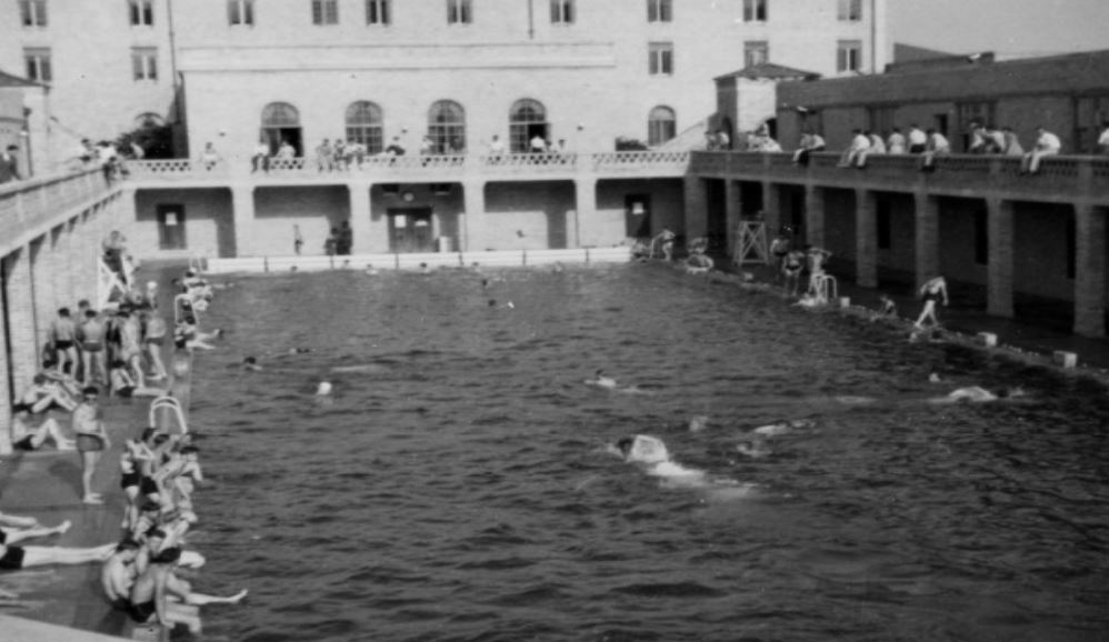 Students swimming in and sitting around the pool at the Huey P. Long Field House