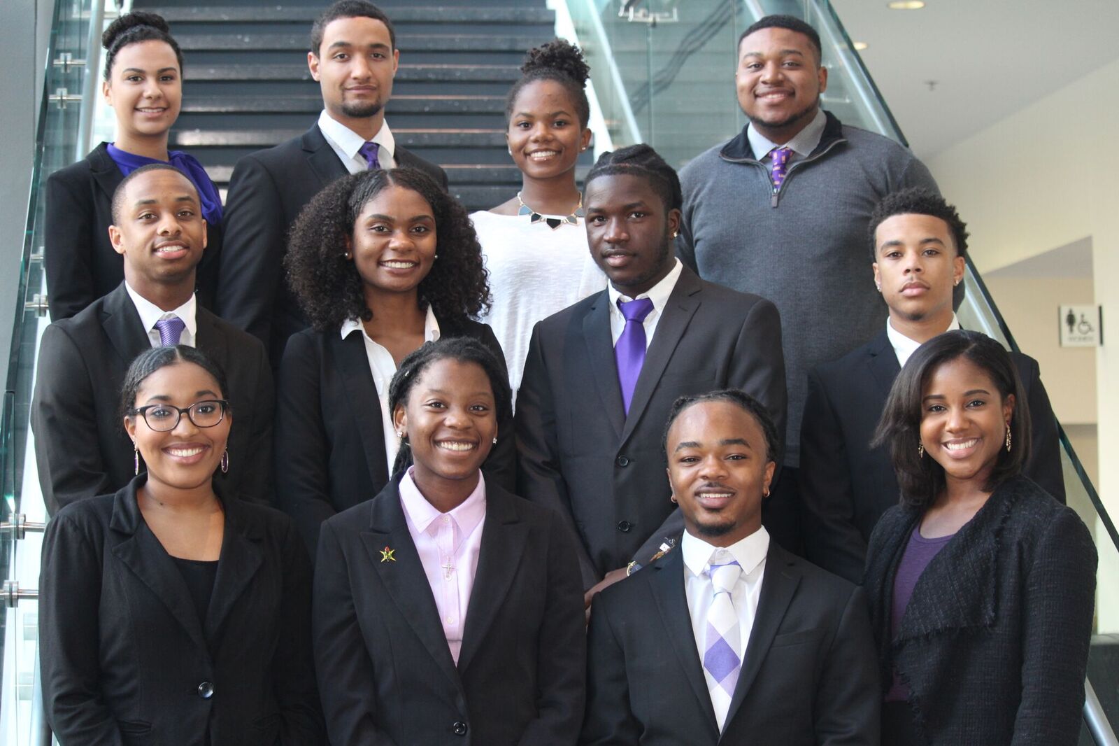 12 students in formalwear posing on stairs