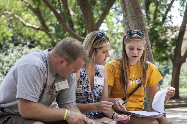 student reviewing paperwork with parents