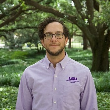 Man grinning in purple polo