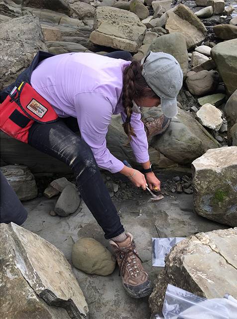 student hammering rocks